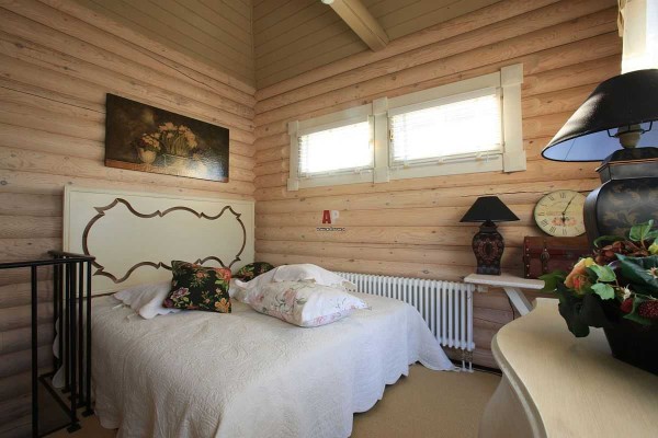 The design of the bedroom in log houses is no different: light, calm tones and several color accents
