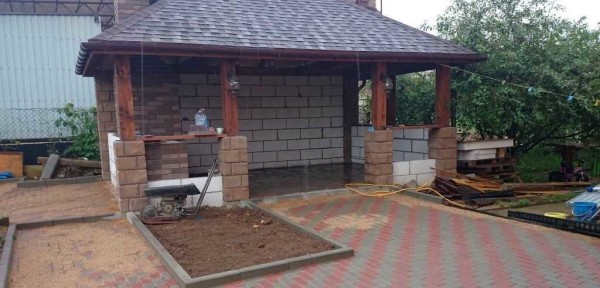 In this project, the walls were laid from foam concrete: it is light and will not create a large overload on one side, then it was revetted with a torn stone