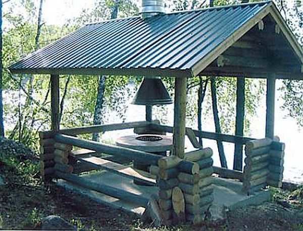 Summer rectangular gazebo made of round timber under a gable roof
