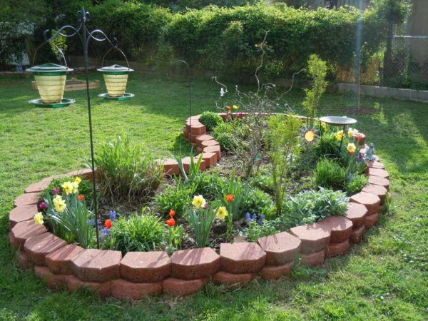 It is not even necessary to fasten two rows of stone or brick with mortar. They can simply be laid out one on top of the other, covered with geotextiles from the inside and covered with earth.