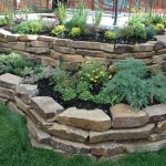 The chipped limestone around the flower beds looks great. Flowerbeds of stones with your own hands can be made in a non-standard or geometric shape