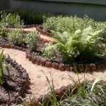 A neatly made flower bed fence made of plastic bottles