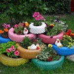 Tires of different sizes painted in different colors are stacked one on top of the other. Simply? Yes! What does it look like? Fine! Economy option of a flower bed for a motorist's summer residence