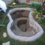 The sides are raised: bricks set upside down and buried at half the height are laid out, concreted on top