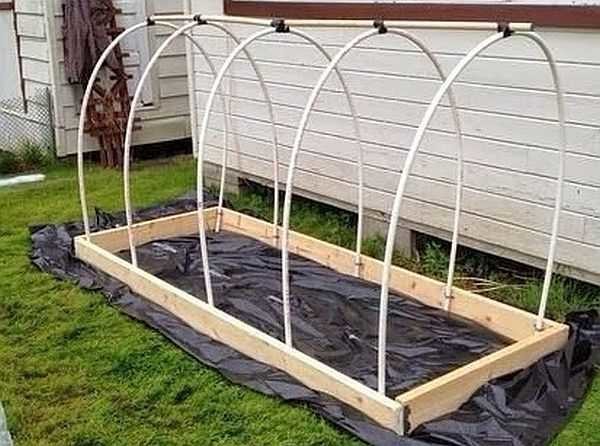 A greenhouse made of PVC pipes according to the same technology with small changes: since it is small, the pipes are nailed directly to the wooden frame. And the upper pipe is also on top and is tied with electrical tape (you can replace it with tape).