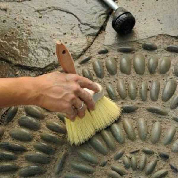 Excess concrete grout is removed with a brush