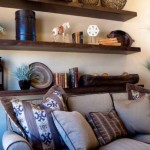 The intimate atmosphere of this room is enhanced by cozy pillows and dark wood shelves.