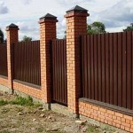 This fence is made of bricks (base and posts) and corrugated board.
