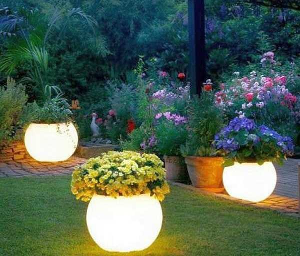 Clay pots painted with luminescent paint in the evening shine no worse than lanterns