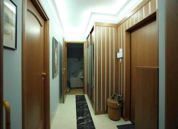 The dark furniture in the narrow hallway is offset by the bright lighting, but the interior still makes a gloomy impression.