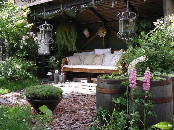 Cozy places and arches, pergolas, flower beds, climbing roses are signs of a romantic style in the design of the site