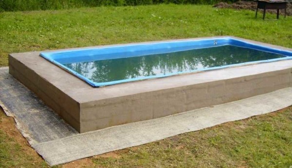 Roofing material is laid on the leveled ground around the pool