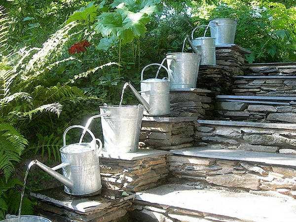 do-it-yourself fountain in the country from watering cans and buckets