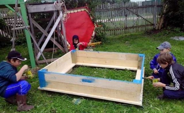 Painting a sandbox in four pairs of hands