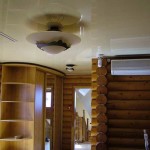 Photo of a hallway in a house made of logs with a stretch ceiling