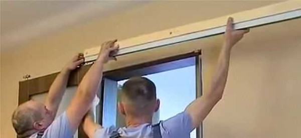 A guide with a bar is rolled onto the rollers on the door