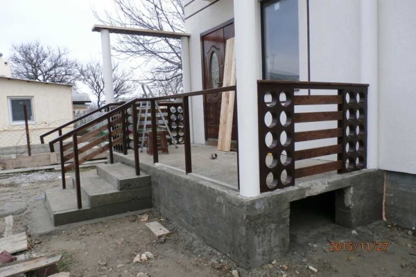 One of the options for a concrete porch with wooden railings