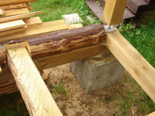 All racks supporting the canopy over the porch of a wooden house are placed on special adjustable lifts