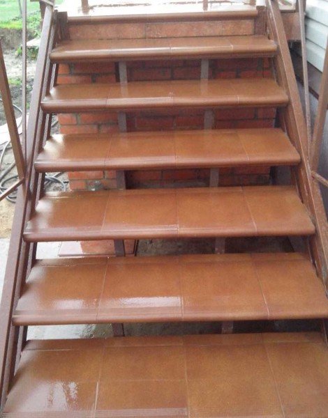 The tile for the steps is selected red-brown to match the color of the brick