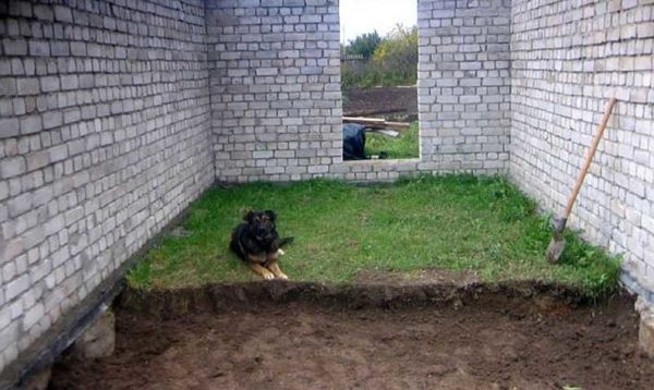 The first stage of the construction of the concrete floor in the garage is the removal of the fertile layer