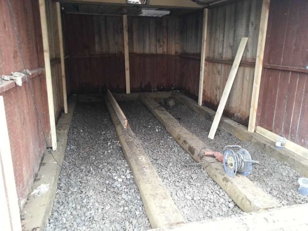 Logs are laid on the tamped crushed stone. In this case, they were laid along, but more often they are laid across