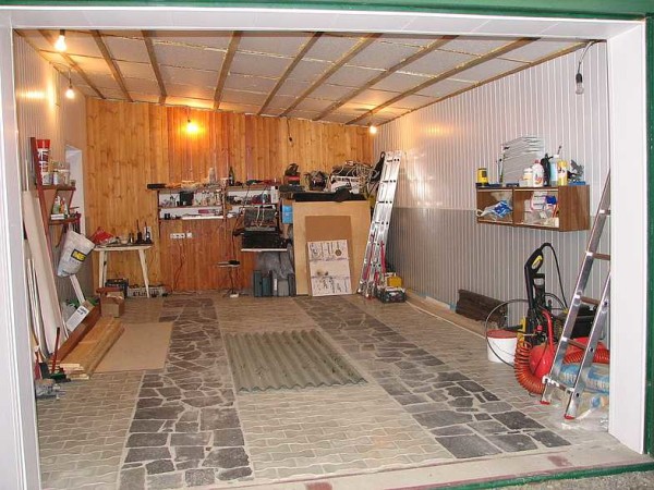 The floor in the garage is made of paving slabs, natural granite slabs are laid under the wheels