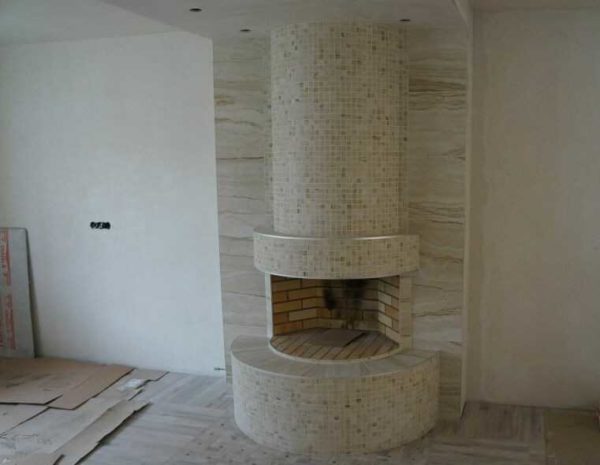 This is unpolished porcelain stoneware, small format. As you can see, it fits well into rounded shapes. Horizontal surfaces and columns are also porcelain stoneware of a similar texture, but already in the form of slabs