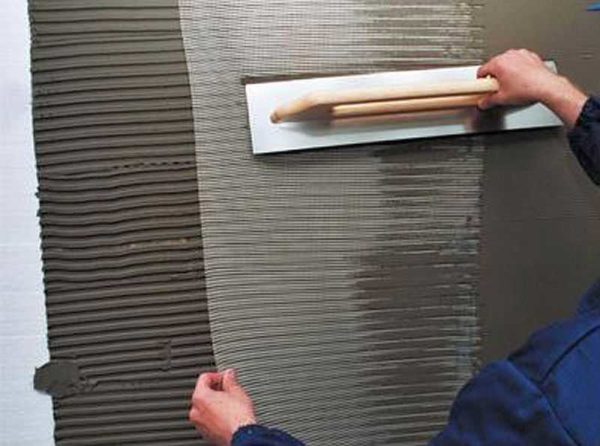 The mesh is rolled out onto the laid layer of glue, pressed into it with a spatula