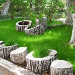 An interesting fence around the lawn - flowerpots made of stumps alternate simply with decks