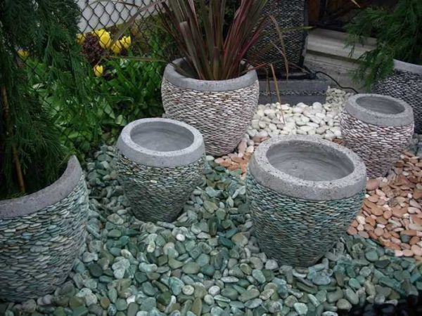 Flowerpots made of concrete, finished with colored pebbles
