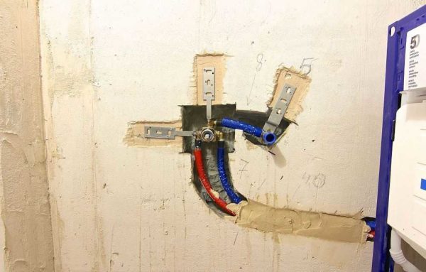 Supply pipes are laid in the wall, a mortgage element is installed, to which the outer part of the mixer is then attached