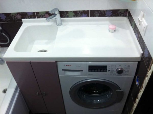Sink above the washing machine with a countertop
