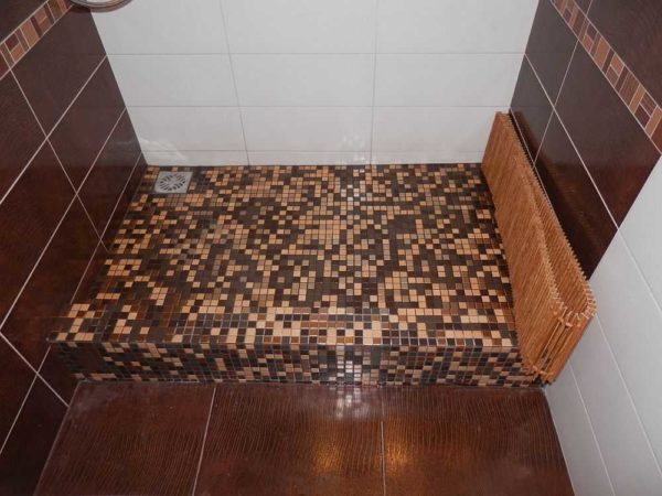 It is not at all necessary to make a drain in the center - it can easily be shifted to any wall. In this case, the farthest wall from the entrance was chosen so that there is less possibility that water will pour out of the booth