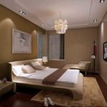 Chandelier in the center, square spotlights lined up along the wall
