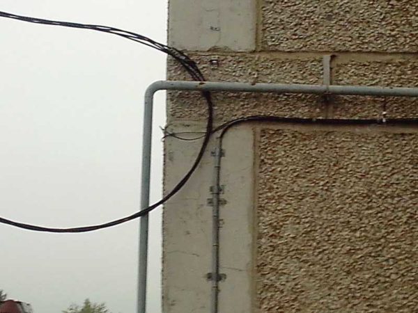 Laying the cable in the pipe.They fix the pipe, and the cable only exits it to the wall