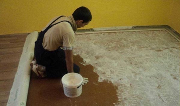 Linoleum adhesive is applied with a roller or spatula