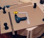 Installing the legs on the lower cabinet of the kitchen unit