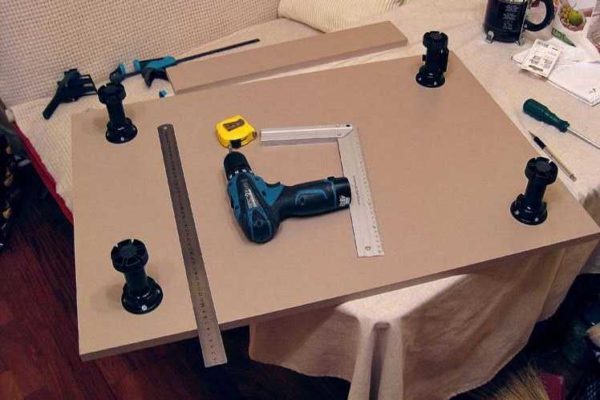 Installing the legs on the lower cabinet of the kitchen unit