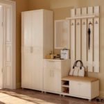 A traditional set in the hallway contains a small wardrobe, a cabinet with a mirror and a hanger