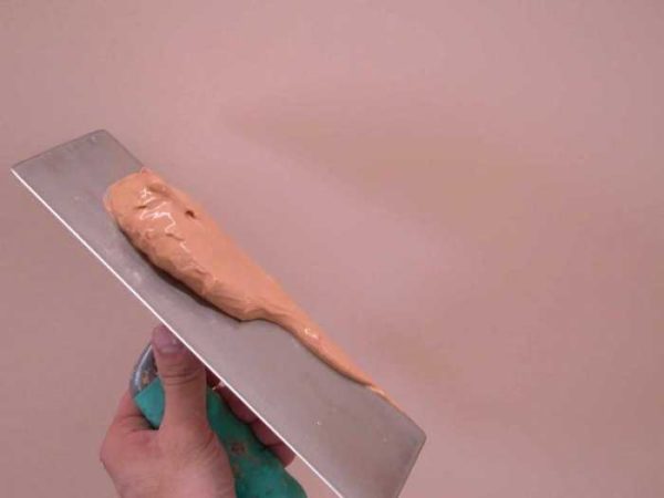 A small amount of the composition is applied to the trowel and rubbed along the wall