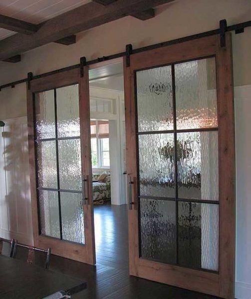 If the design has deliberately emphasized wooden elements, it makes sense to make the door frame from wood (or plastic) of the same color