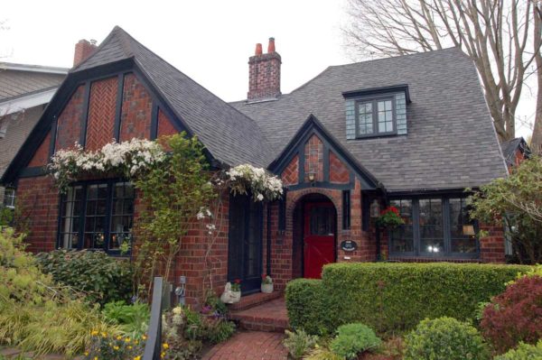Red brick in various shades and dark brown beams, gabled roof with living areas ...
