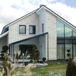 White brick house in a modern style. Brightness to the facade is given by a contrasting finish