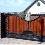 Representative of the second type - forged gates and fence covered with boards