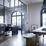 A glass partition in a metal frame and openwork stucco molding emphasize each other