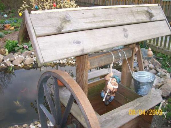 Cute gnome as decoration of the well