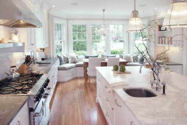 Kitchen design with a large bay window: island kitchen and sofa