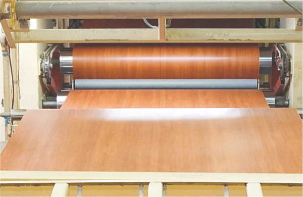 Melamine paper is laid on the prepared sheet, then fed to the press